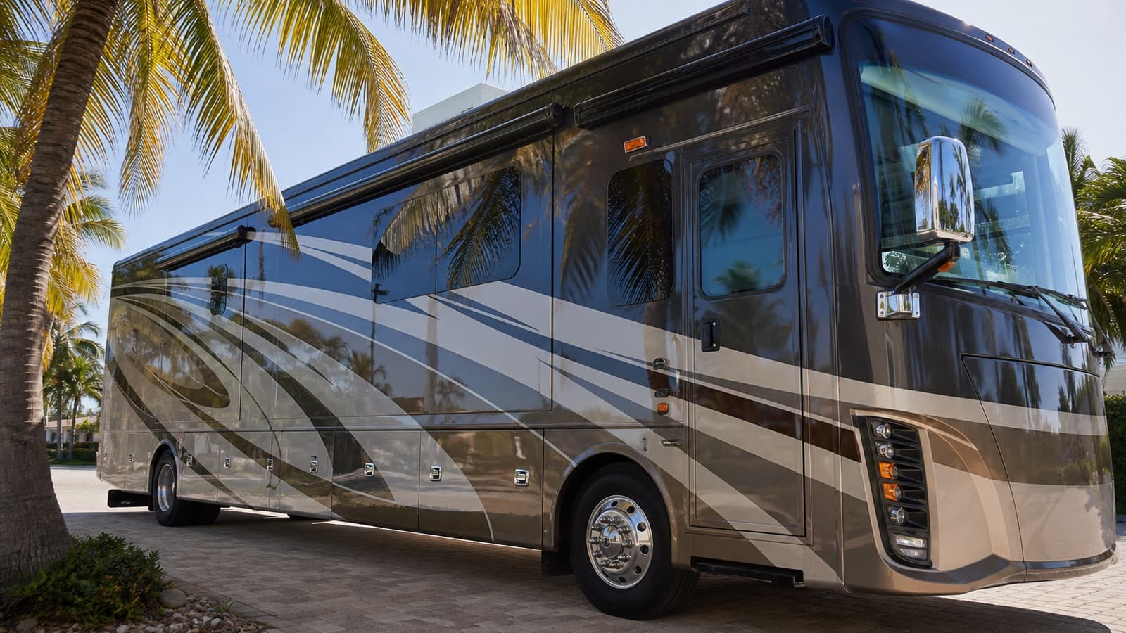 Unbranded premium Class A motorcoach parked beneath palms with lower storage-bay doors visible